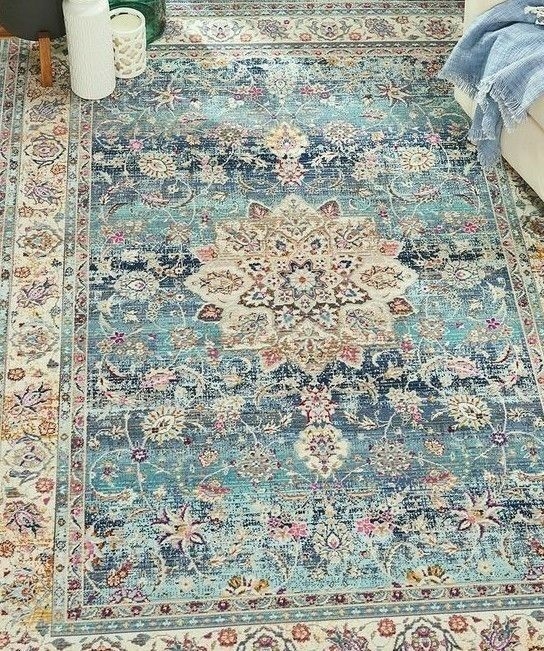 a blue rug with an ornate design on the floor in a living room or bedroom