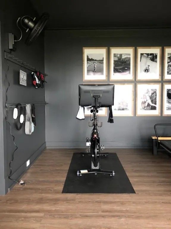 a bike is sitting in the middle of a room with pictures on the wall behind it