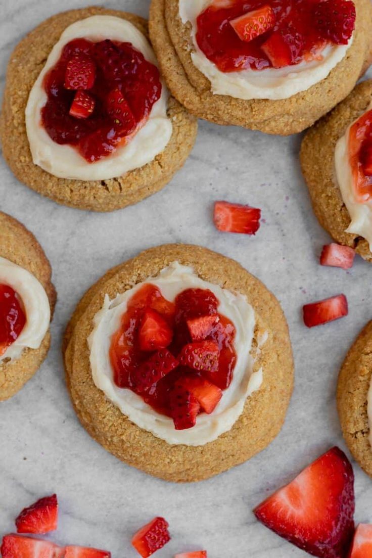 strawberry shortcakes with whipped cream and fresh strawberries on top are arranged on a marble surface