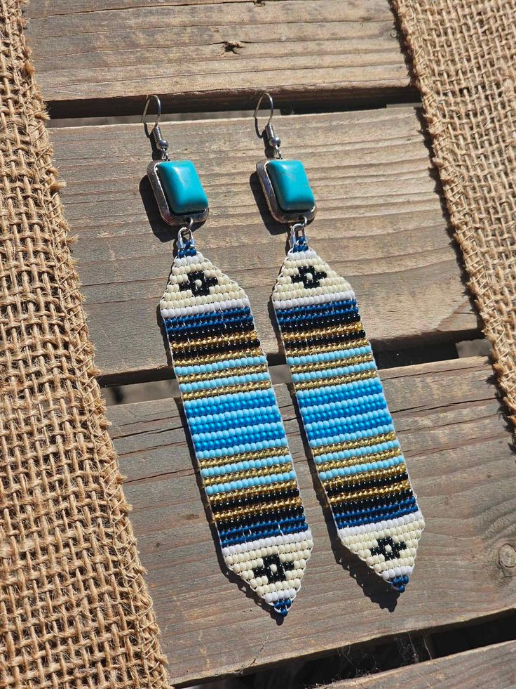 pair of beaded earrings on wooden planks