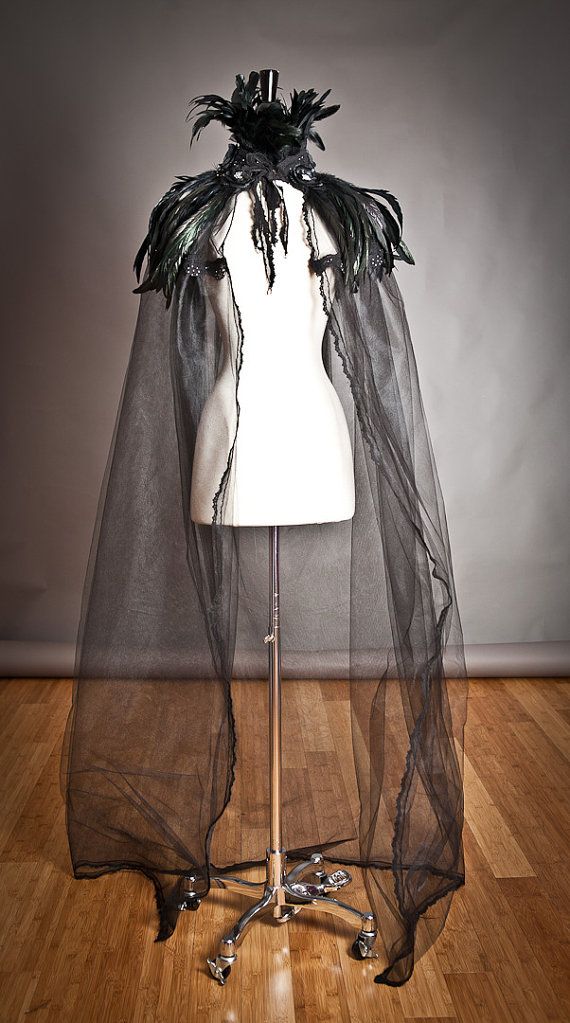 a mannequin wearing a black veil on top of a wooden floor