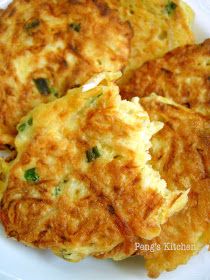 three fritters on a white plate with green onions and parmesan cheese