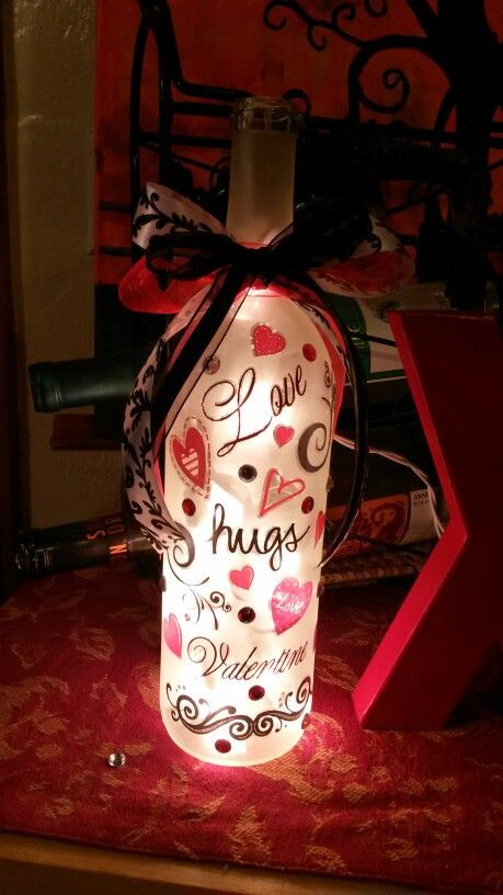 a lighted bottle with the words love hugs on it sitting on top of a table