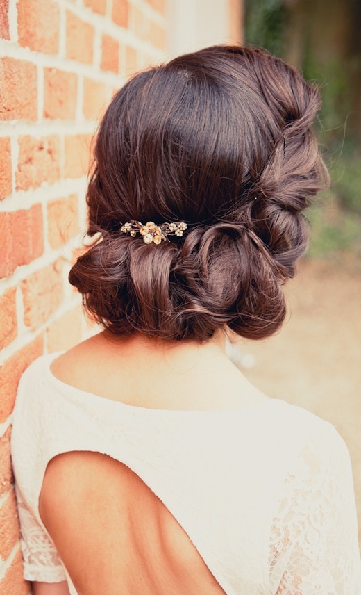 a woman leaning against a brick wall with her back to the camera