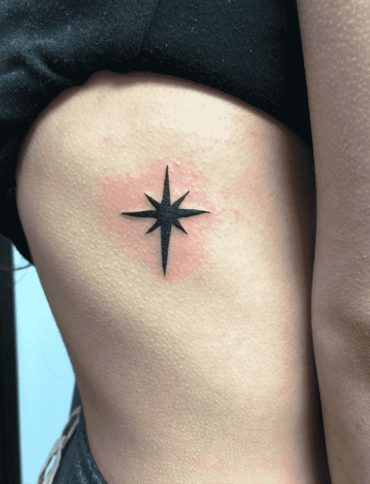 a woman's thigh with a small star tattoo on her lower side ribcage