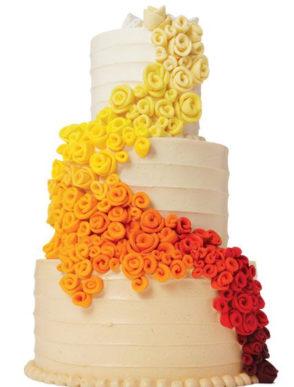 a multi - tiered cake decorated with flowers and icing on a white background