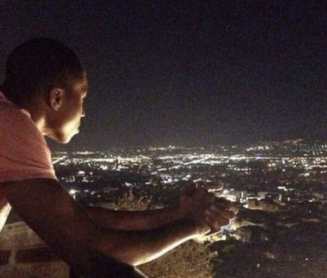 a man looking out over the city at night