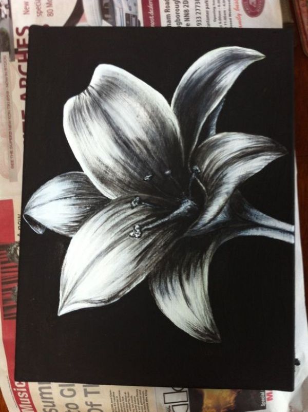 a black and white drawing of a flower on top of some newspaper paper with other papers in the background