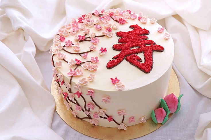 a white cake with pink and red flowers on it