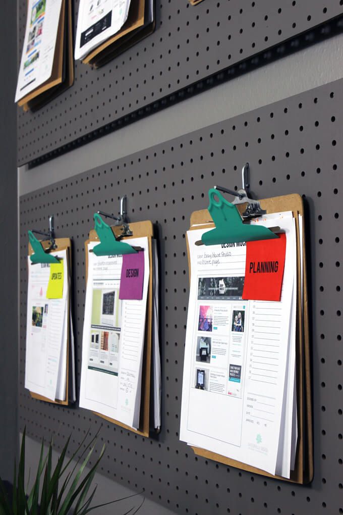 three bulletin boards are attached to the wall with clippings on them and hanging from pegs