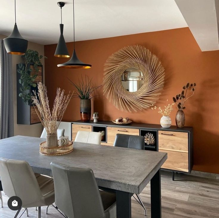 a dining room with orange walls and chairs