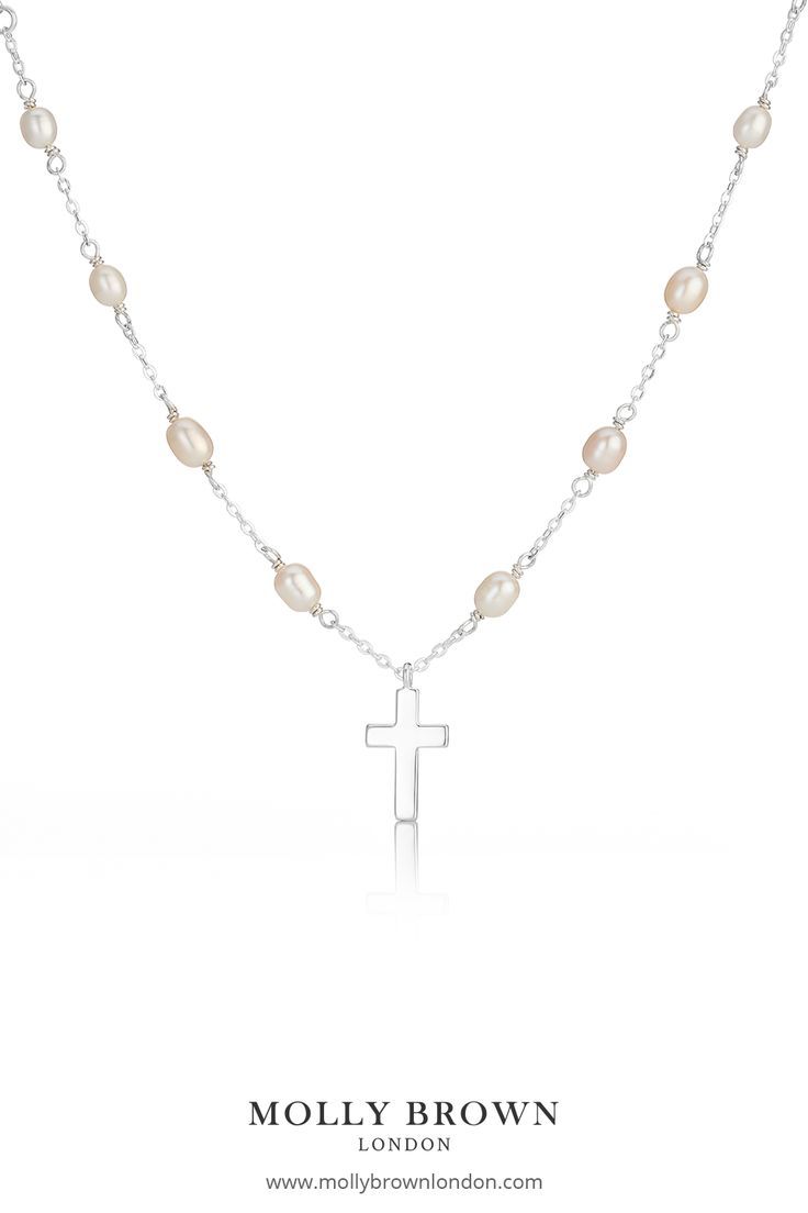 Designed using freshwater pearls the Cross on Pearl Station Necklace features a sterling silver cross set on the 16" freshwater pearl necklace adjusted at 14" to fit most ages. The cross measures 10mm in width 2mm in depth and a total drop of 15mm sitting delicately upon the pearls. This necklace would make a beautiful gift for a Baptism or Holy Communion. #holycommuniongift #holycommunionjewelry #holycommuniongiftgirls #girlsrosary #girlscross #childrensjewelry #mollybrownlondon # pearlcross Silver Cross Necklace With Pearl Chain As Gift, Pearl Drop Necklace With Cross Pendant For Gift, Pearl Drop Cross Pendant Necklace As Gift, Pearl Drop Necklace With Cross Pendant As Gift, Cross Pendant Necklace With Pearl Drop Gift, Pearl Cross Necklace With Pearl Drop As Gift, Silver Cross Necklace With Pearl Chain For Gift, Silver Cross Pendant Pearl Necklace As Gift, Silver Cross Necklace With Pearl Drop