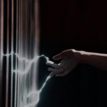 a person's hand is touching a wall with lightening lines on it in the dark