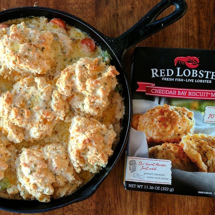 a cast iron skillet filled with crab cakes next to a packet of red lobster biscuits