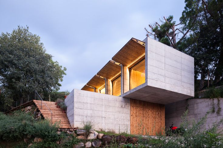 the house is made out of concrete and has stairs leading up to it's upper level