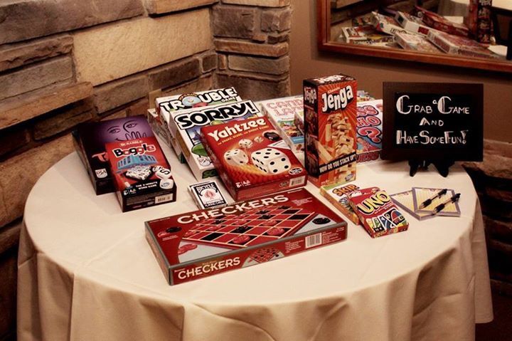 a table topped with lots of games and cards on top of a white table cloth