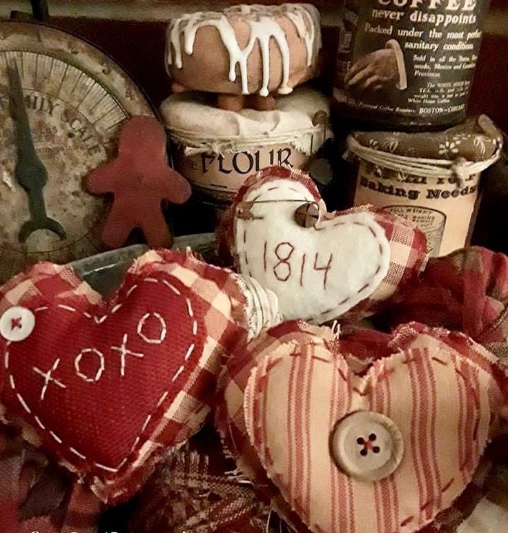 two heart shaped pillows sitting next to each other on top of a pile of fabric