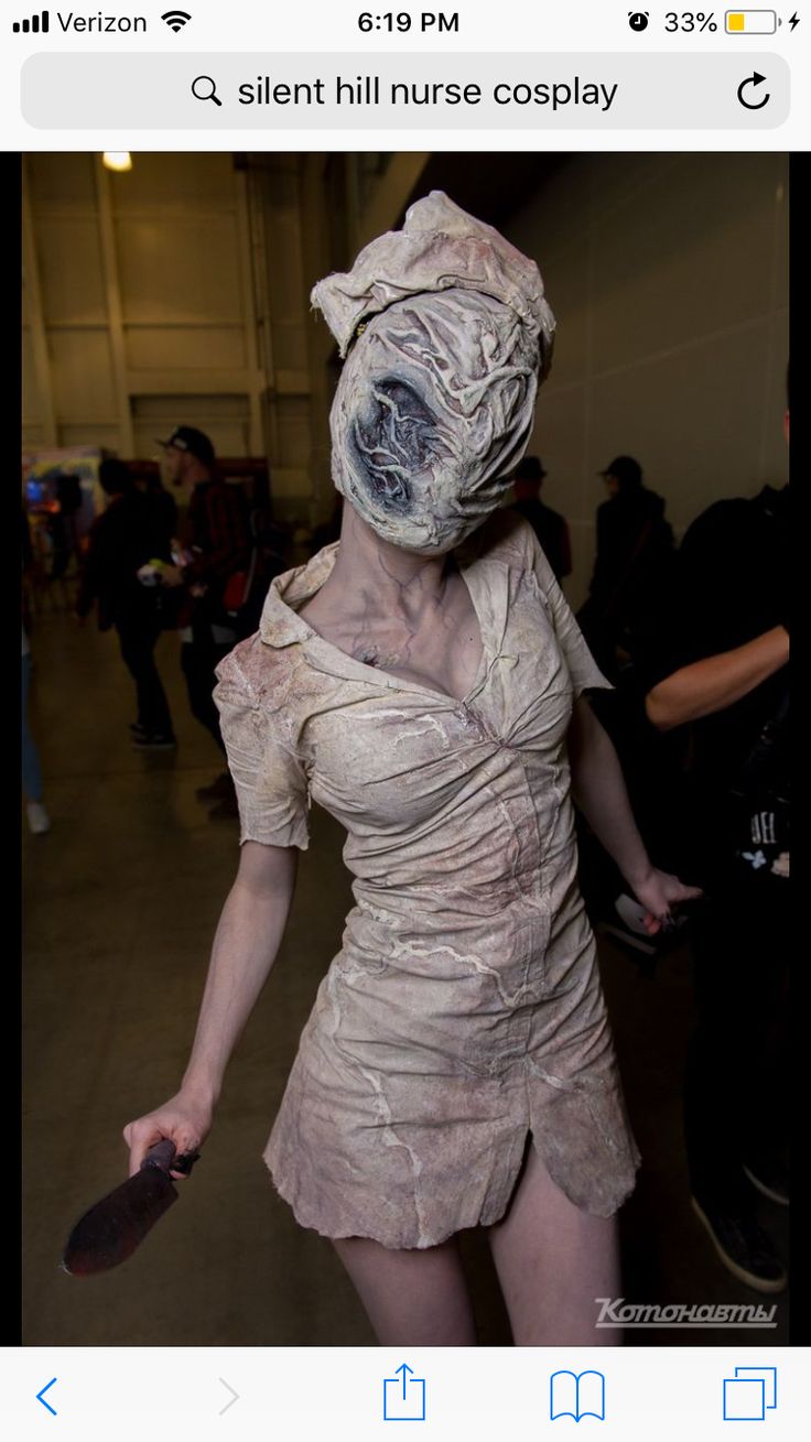 a woman dressed up as a zombie holding a skateboard in her hand and walking through an airport