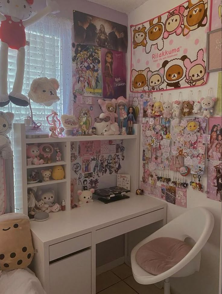 a white desk sitting under a window next to a wall covered in pictures and stuffed animals