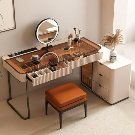 a desk with a mirror, stool and other items on it