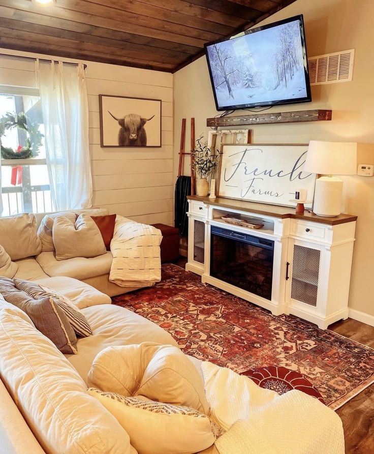 a living room filled with furniture and a flat screen tv mounted on the wall above a fireplace