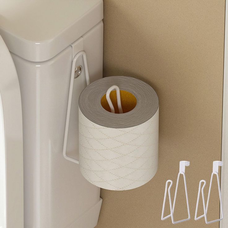 a toilet paper dispenser next to a roll of toilet paper on the wall