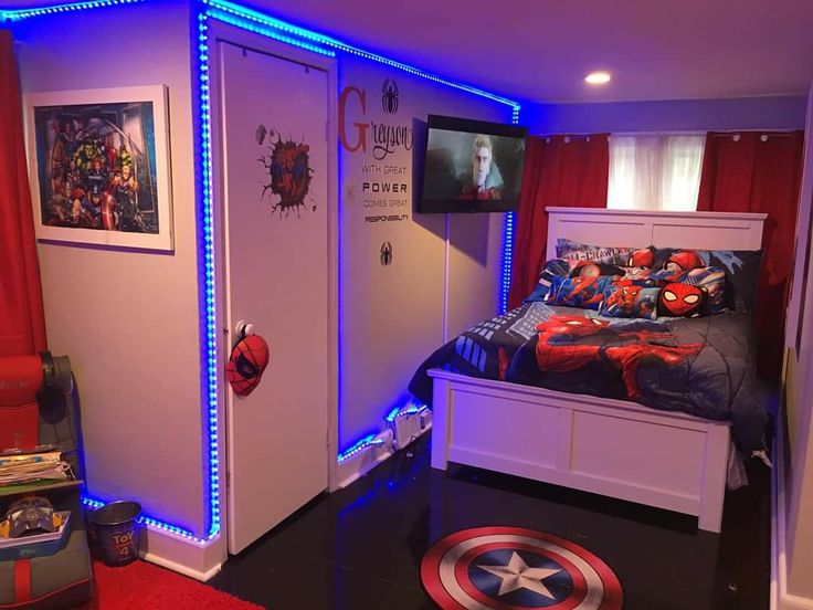 a room with a bed, chair and pictures on the wall behind it is lit up by blue lights