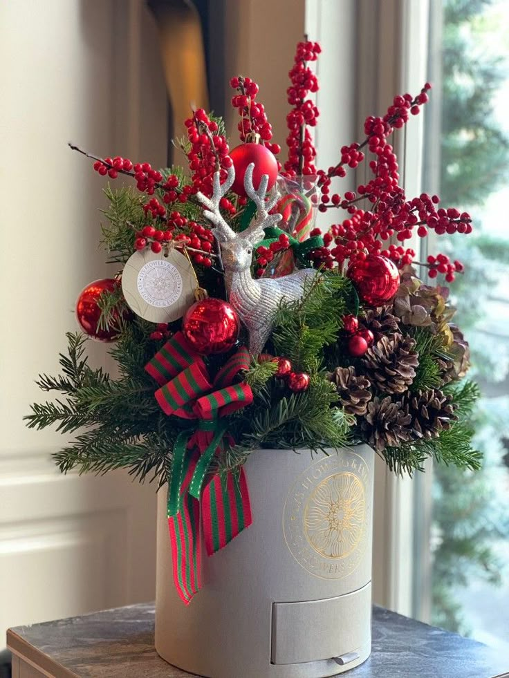 a christmas arrangement in a hat box on a table