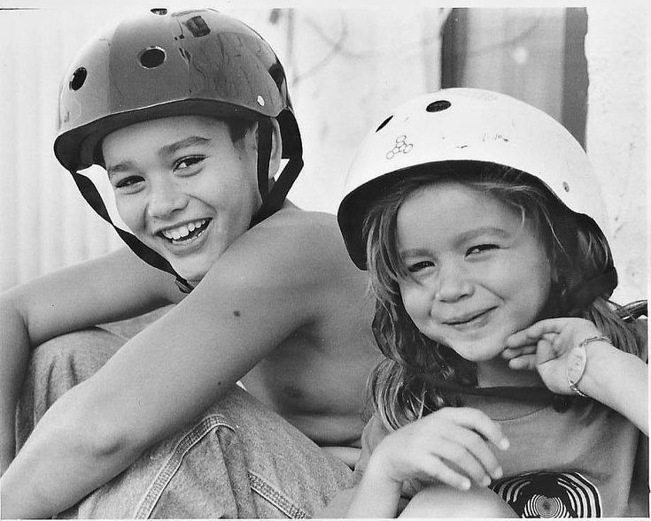 two children wearing helmets sitting next to each other