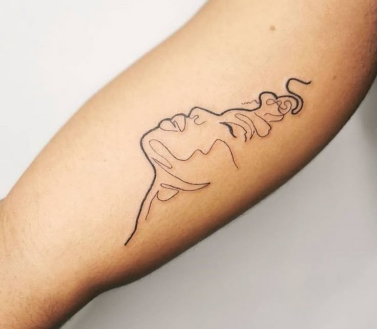 a person's arm with a tattoo on it that has an outline of a woman