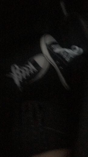 a person's feet in the dark with their shoes on