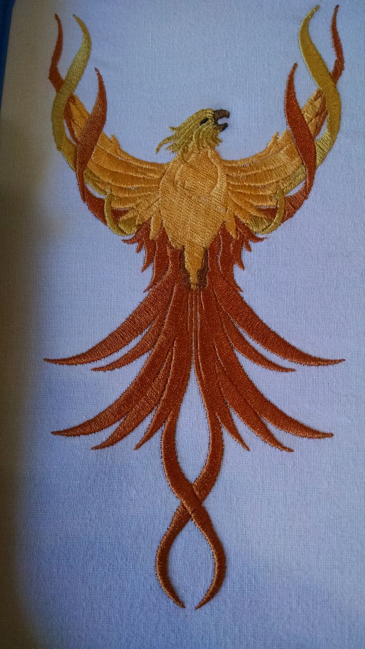 an embroidered bird on a white shirt with red and yellow feathers in the shape of a spiral