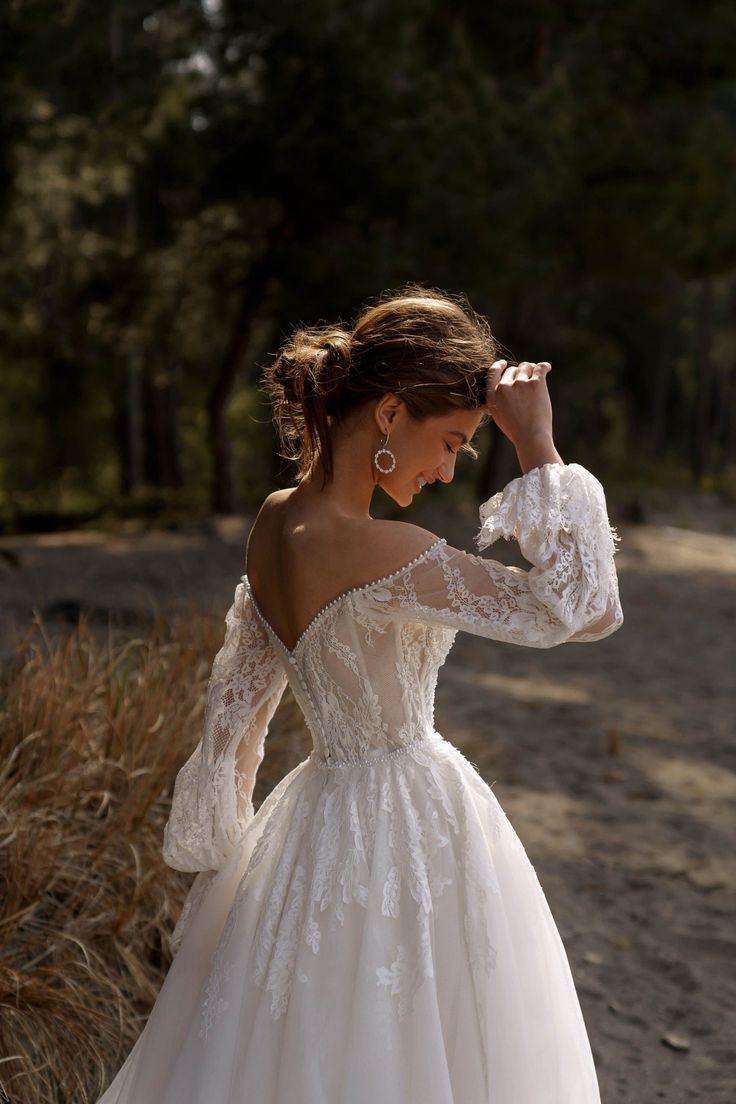 a woman in a wedding dress is posing for the camera with her hand on her head