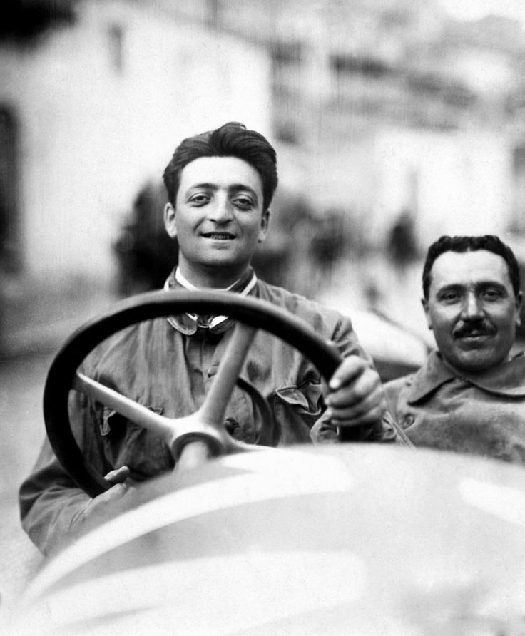 two men sitting in the driver's seat of a car