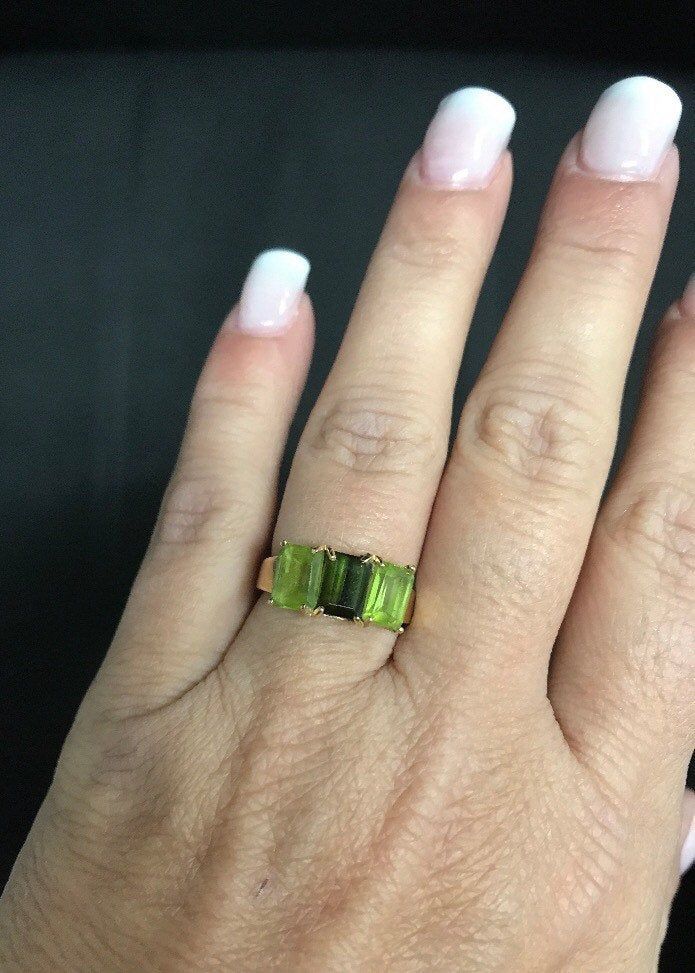 Beautiful Peridot 14K Yellow Gold Ring It is a size 6. Total weight of 3.3 grams solid 14K gold, stamped inside the ring. Features two rectangular peridot 12mm x 5mm and one rectangular dark green 12mm x 5mm center stone. I am unsure if it is an emerald? Or darker peridot. It is a beautiful ring and it will look beautiful on any one who wears it! Shipped insured/delivery confirmation I guarantee item to be exactly as described and pictured. 14k Gold Green Rectangular Ring, Rectangular Green 14k Gold Ring, Green Rectangular 14k Gold Ring, Rectangular Green Peridot Rings, Green Rectangular Anniversary Ring, Ruby Heart Pendant, Black Opal Pendant, Green Ring, Green Rings