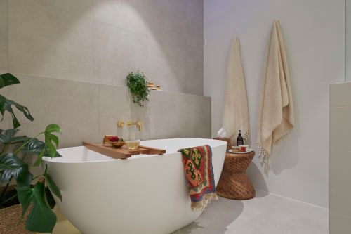 a bath tub sitting next to a plant in a bathroom