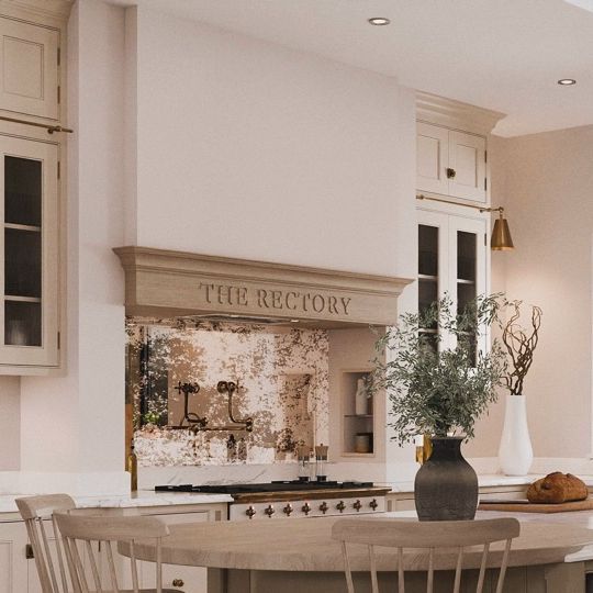 a large kitchen with white cabinets and an island in the middle is decorated with vases