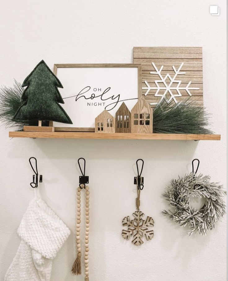 a shelf with christmas decorations and ornaments on it, hanging from the wall next to a sign that says merry