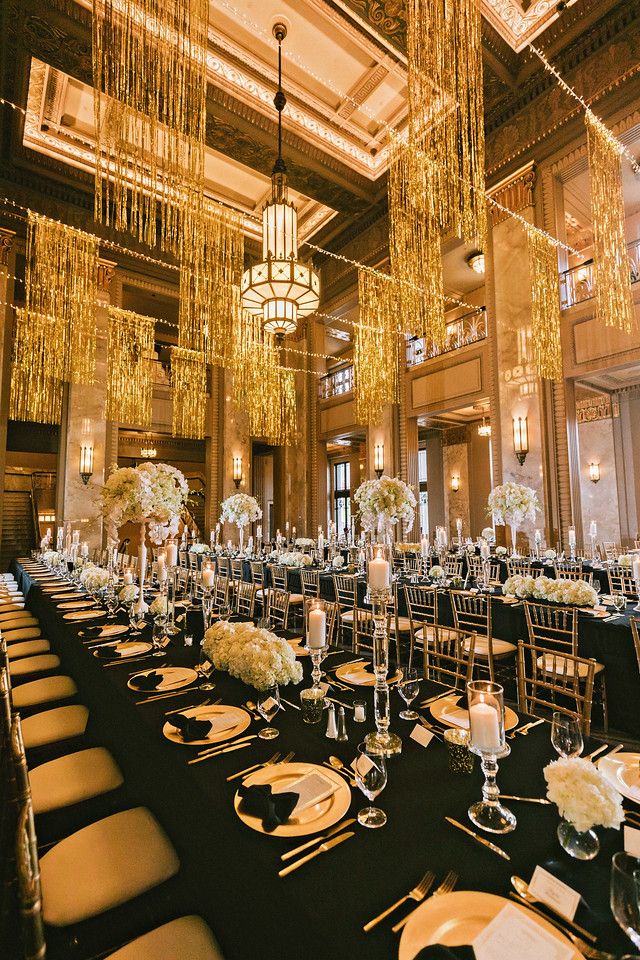 the tables are set for an event with chandeliers hanging from the ceiling and centerpieces