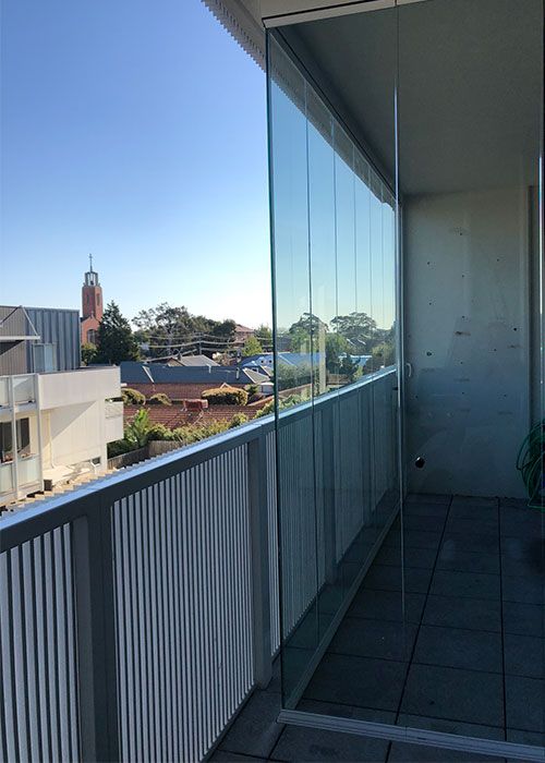 a balcony with a view of the city from it's glass walls and railings