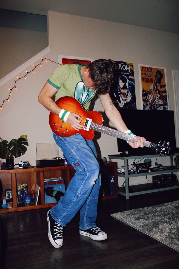 a man playing an electric guitar in his living room