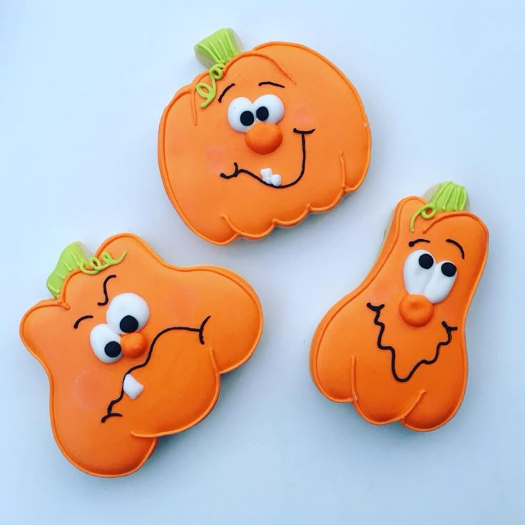 three cookies shaped like carrots with googly eyes