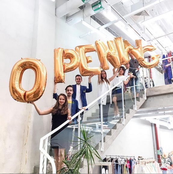 group of people holding up large gold balloons that spell out the word peperis