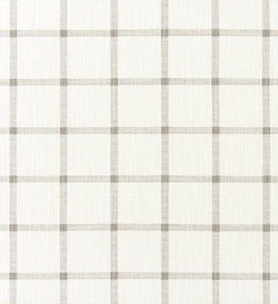 a white and grey checkered fabric with a ruler in front of the plaid pattern