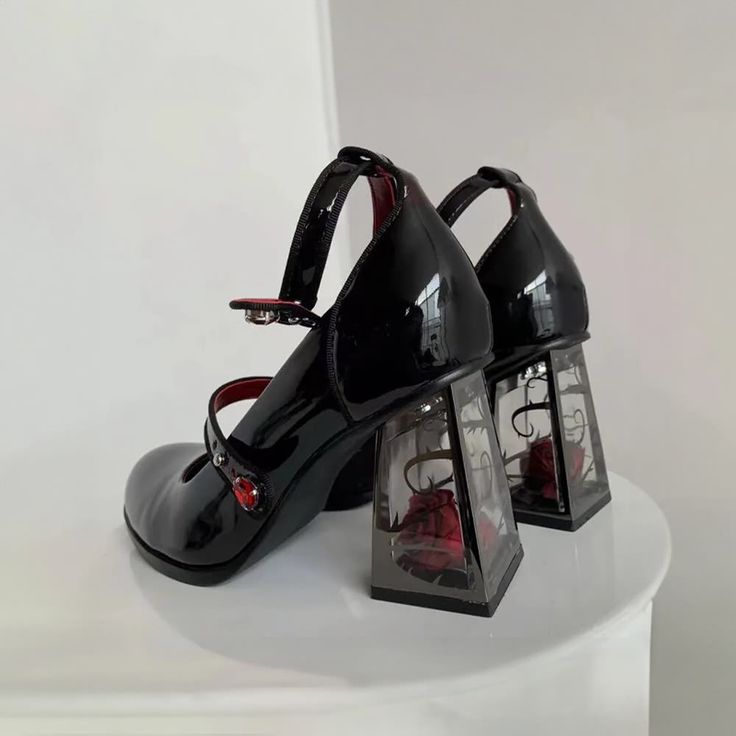 These Dark Romantic Gothic Rose High Heels are expertly crafted for fashion enthusiasts who appreciate dark aesthetics. With a combination of chunky, pump, and mary jane heel styles, these heels offer a unique and captivating design. The striking red and black color palette creates a mysterious and alluring vibe, making them perfect for goth, punk, or grunge looks. Made from vegan leather, these heels feature transparent block heels with real rose accents inside. The adjustable buckle ankle stra Gothic High Heels, Black Mary Jane Shoes, Mary Jane Platform Shoes, Zapatos Mary Jane, Punk Shoes, Gothic Rose, Dr Shoes, Gothic Shoes, Cosplay Shoes