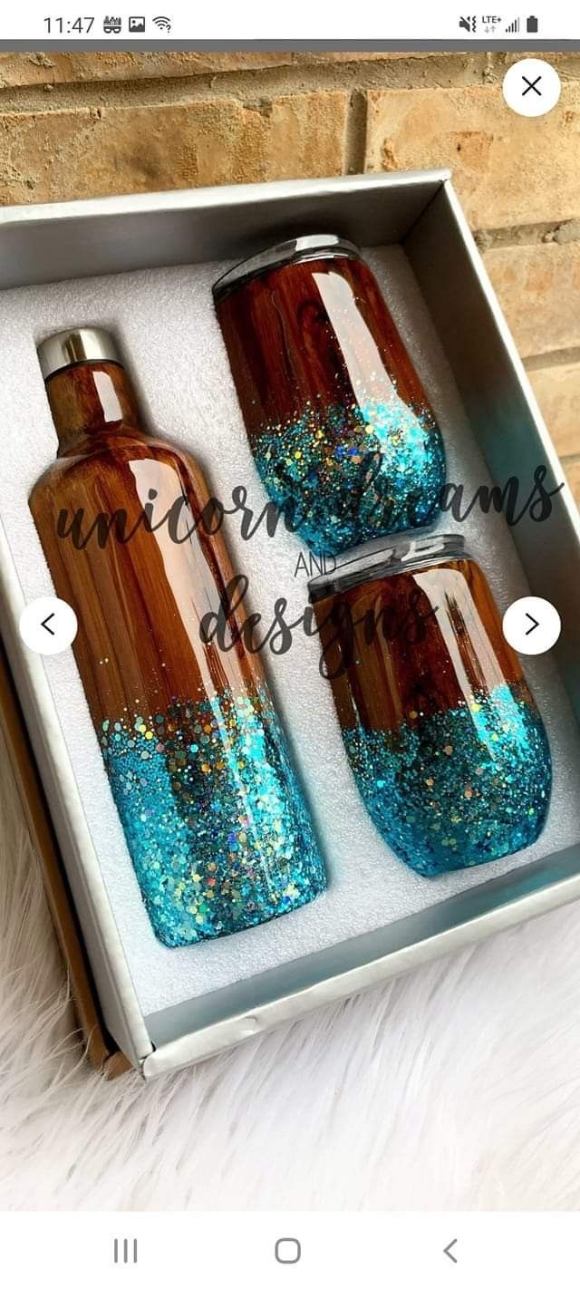 two bottles with blue glitter on them in a box