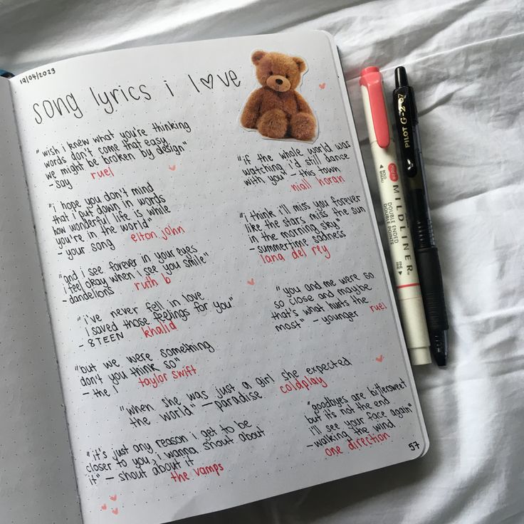 an open notebook with writing and a teddy bear