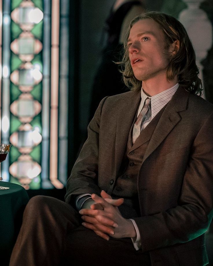 a man in a suit and tie sitting down