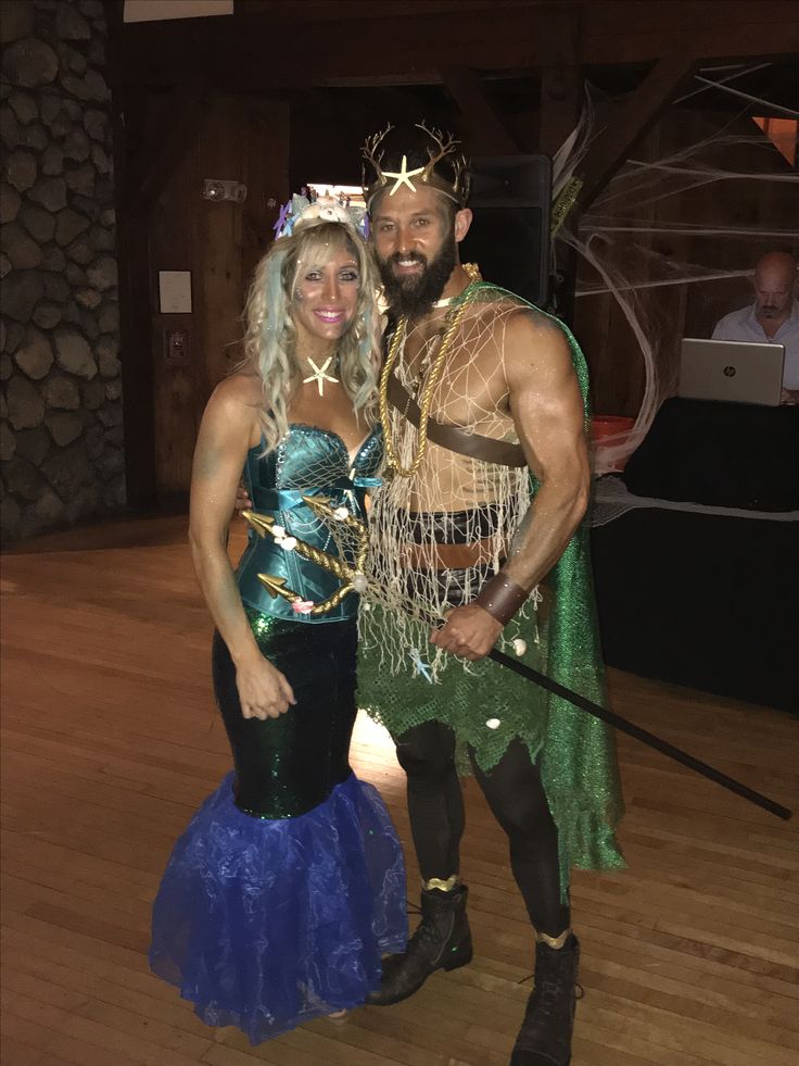 a man and woman dressed up as mermaids pose for a photo on the dance floor