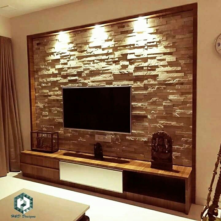 a living room with a flat screen tv mounted to the side of a brick wall